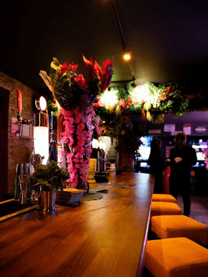 The bar at Azuro, with a flower arrangement and warm lighting